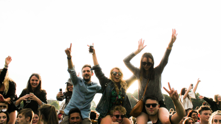 Unge til fest på skulderen af andre unge